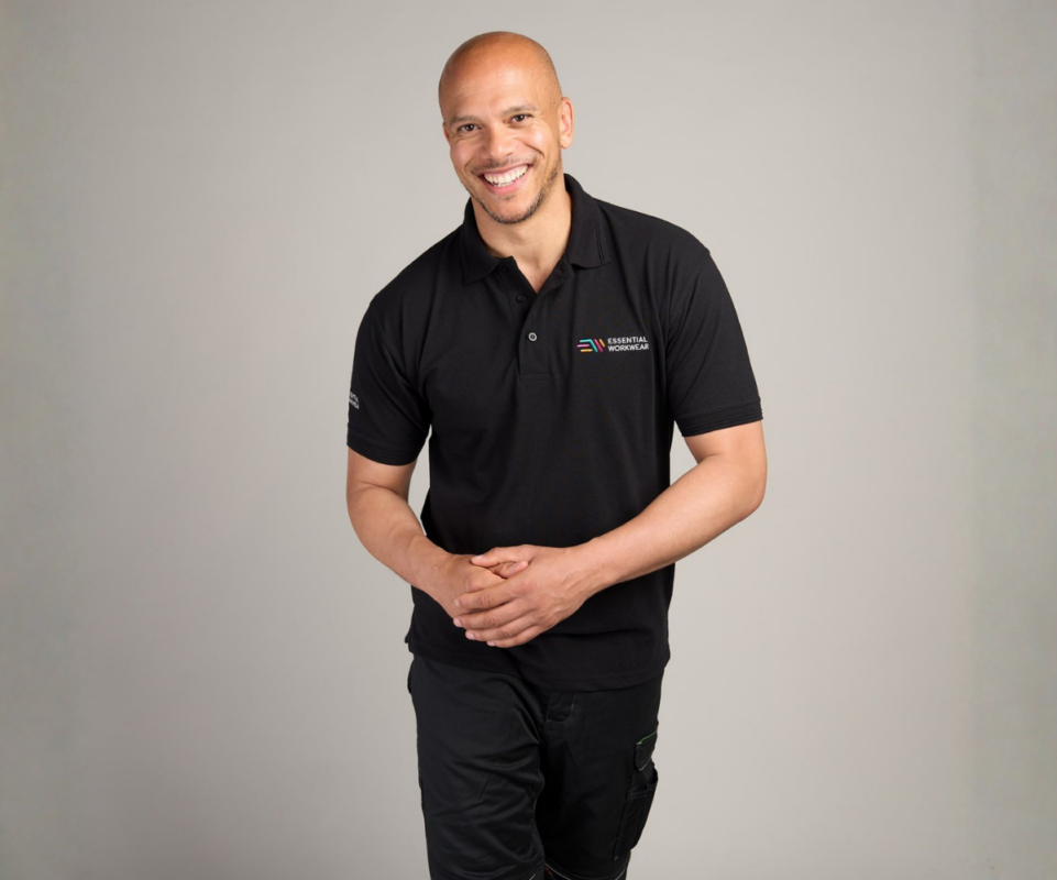 Male looking happy wearing a black branded polo shirt
