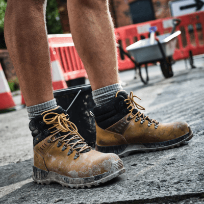 Construction worker wearing lace up safety work boots outdoors on construction site