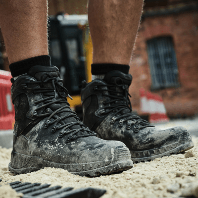 sand-covered safety work boots being worn outdoors on job site