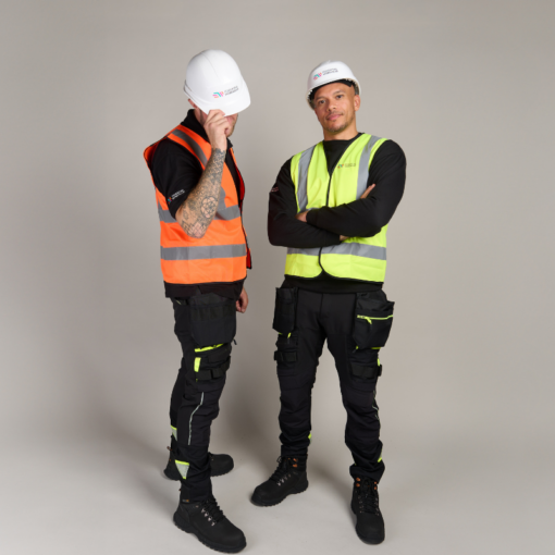 two men wearing hard hats and hi-vis vests