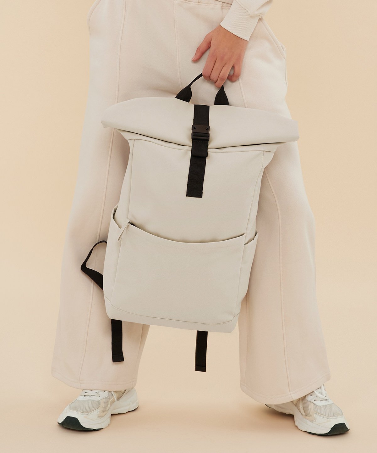 Premium Recycled Roll Top Backpack 6 a girl holding a bag between with a hand her legs