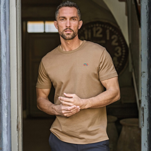 man wearing tee jays interlock t-shirt with branding on