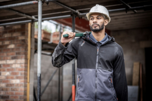 man working on a construction site wearing uniform and a hard hat